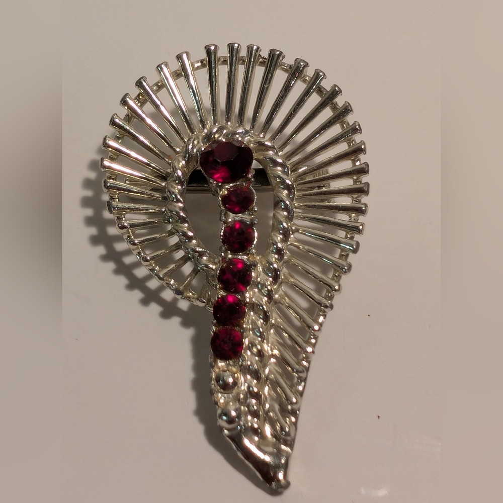 This is a vintage Silver Metal brooch with ruby red rhinestones.
